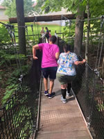 camper and counselor crossing bridge