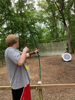 camper shooting the bow and arrow